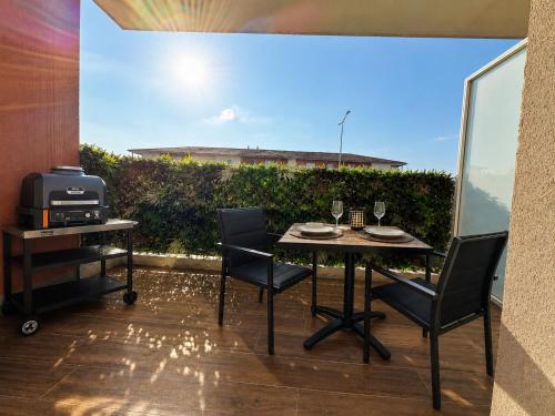 a patio with a table and chairs and a window at Suite Eden Spa, Appart'hôtel bien être , Patio de standing barbecue - TV XL CinéSport, Lit Q-Size, Wifi, P-Gratuit en Résidence in Avion