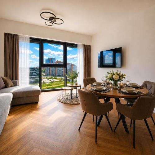 a living room with a table and chairs and a couch at Olszynki Park Elite Residence in Rzeszów