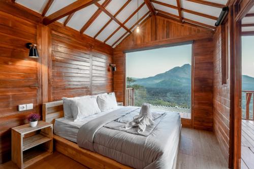 a bedroom with a bed and a large window at Kamani Cabin by Moria in Kubupenlokan