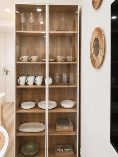 a glass cabinet filled with plates and bowls at Sisargas Playa in Malpica