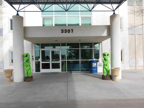 a building with two green alien statues in front of it at Motel 6-Roswell, NM in Roswell