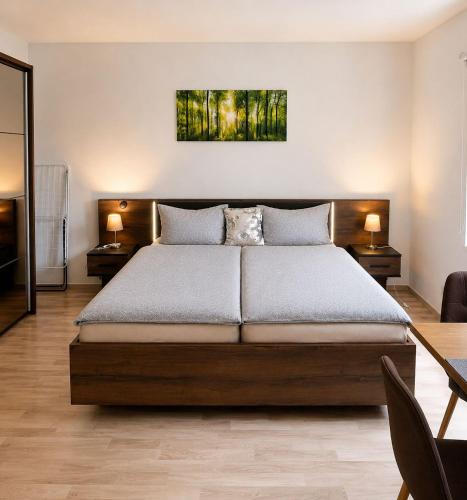 a bedroom with a large bed with two tables and two lamps at Gut Rottmannshagen Mecklenburgische Seenplatte in Jürgenstorf