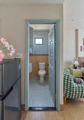 a bathroom with a toilet and a sink and a door at LangX Heaven Hotel & Apartment in Danang