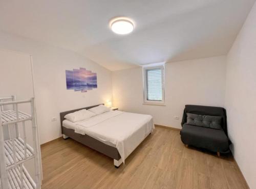 a bedroom with a bed and a chair in it at Apartments Vicelić in Lovište