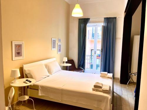 a bedroom with a white bed and a window at Torrearsa 17 in Trapani