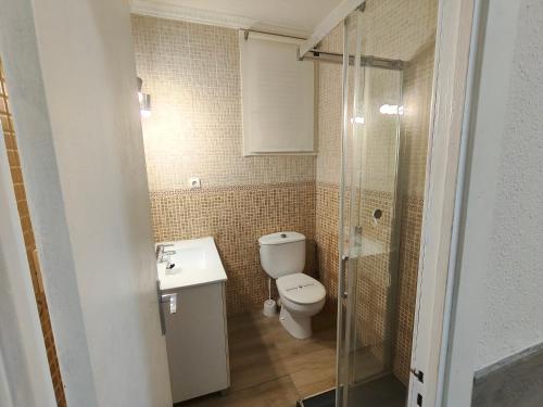 a bathroom with a toilet and a sink and a shower at Apartaments Lamoga - Sandi in Torredembarra
