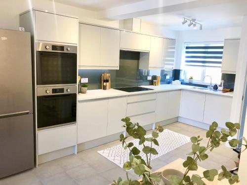 a kitchen with white cabinets and a stainless steel refrigerator at Spacious En-suite Private Double Bedroom in Oxford