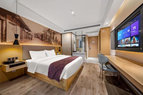a hotel room with a bed and a flat screen tv at Mercure Chengdu Downtown Hotel in Chengdu