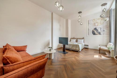 a living room with a couch and a tv at Lumiere 28 Aparthotel in Łódź