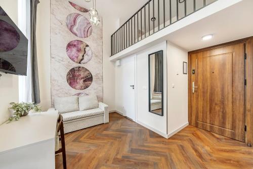 a living room with a staircase and a wooden door at Lumiere 28 Aparthotel in Łódź