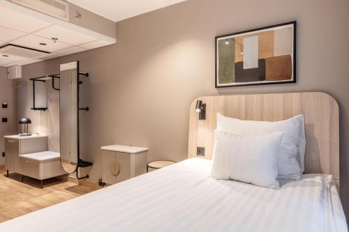 a bedroom with a white bed and a bathroom at Scandic Grand Marina in Helsinki