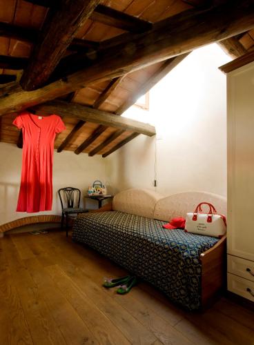 a bedroom with a bed and a red shirt hanging on a wall at Hotel Corallo in Pomonte