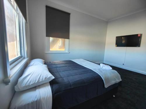 a bedroom with a bed and a tv on the wall at The Club Hotel Collie in Collie