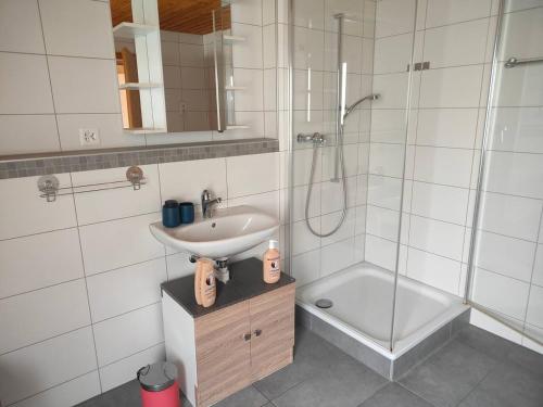 a white bathroom with a sink and a shower at 20 Min nach Interlaken in Frutigen