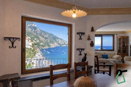a living room with a large window overlooking the ocean at Hotiday Positano Suites and View in Positano