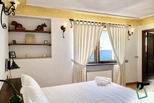 a bedroom with a white bed and a window at Hotiday Positano Suites and View in Positano