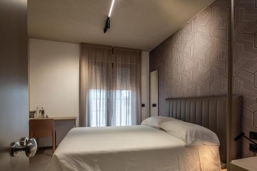 ein Schlafzimmer mit einem weißen Bett und einem Fenster in der Unterkunft Hotel Costa Azzurra in Grado