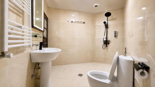 a white bathroom with a sink and a toilet at Royal Delegation Suite in Kabul