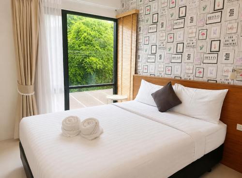 a bedroom with a bed with two towels on it at Palmari Boutique Hotel in Ban Nua Khlong