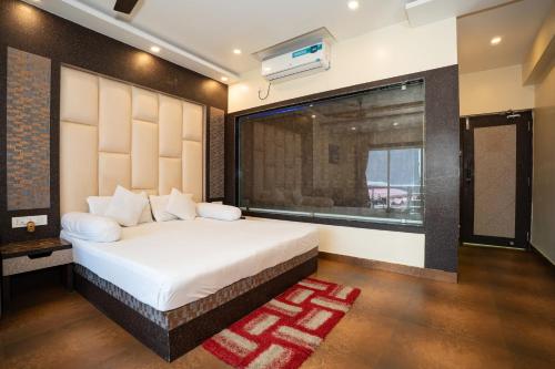 a bedroom with a large bed and a window at Sher Bengal Beach Resort in Mandarmoni