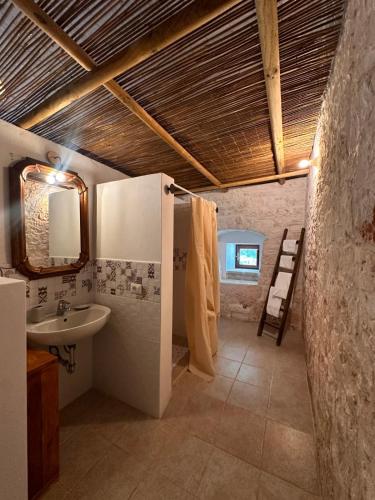 a bathroom with a sink and a toilet and a mirror at Giardino dei Trulli Cummerse in Faccia di Trippa di Monte
