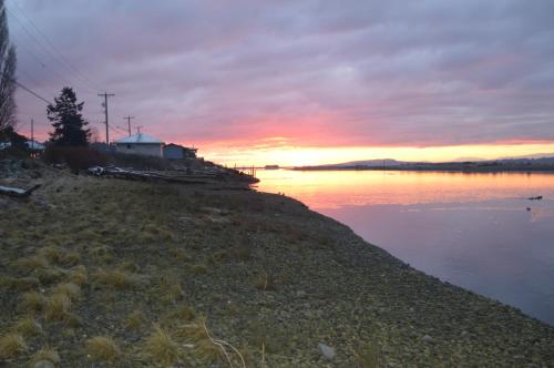 a sunset on the shore of a body of water at Estuary House Reflexology B&B in Courtenay
