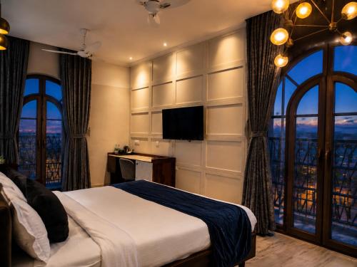a bedroom with a bed and a large window at The Belmonte House by Noventa - Rooftop Pool Hotel in Udaipur in Udaipur