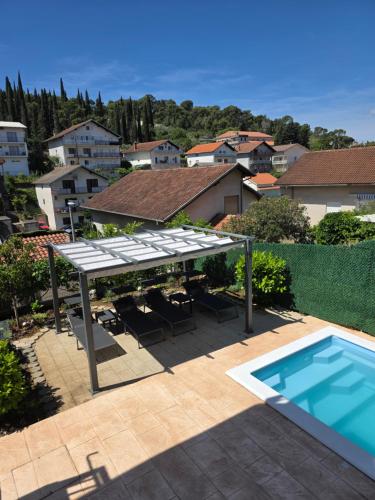 a patio with a table and a swimming pool at Beautiful Holiday Home "Villa Relax Oasis" in Trogir