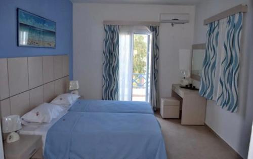 a bedroom with a blue bed and a window at Thealos in Azolimnos Syros