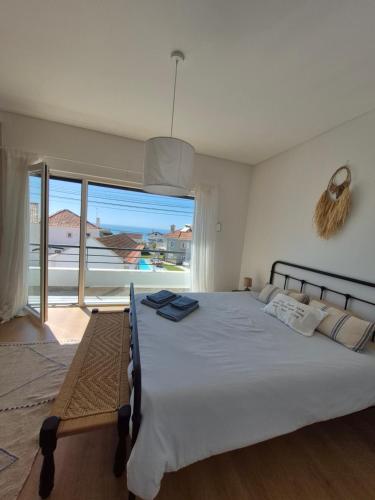 a bedroom with a bed with a view of the ocean at Ribavilla Surf House in Santo Isidoro
