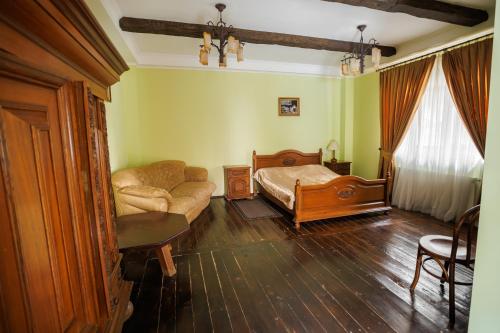 a living room with a bed and a couch at Avenue Hotel in Chernivtsi