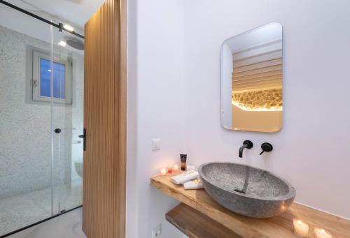a bathroom with a stone sink and a mirror at Nevo Mykonos in Mikonos