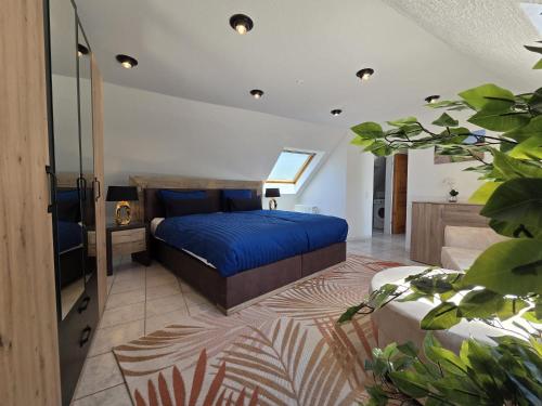 a bedroom with a bed with a blue bedspread at Ferienhaus Eifel Horizont in Neuheilenbach
