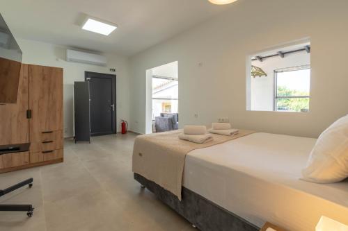 a large bedroom with a large bed and windows at Green Galini Villa Pelion - the small unit in Platanidia