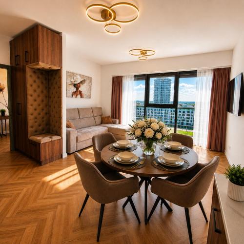 a living room with a table and chairs at Olszynki Park Elite Residence in Rzeszów