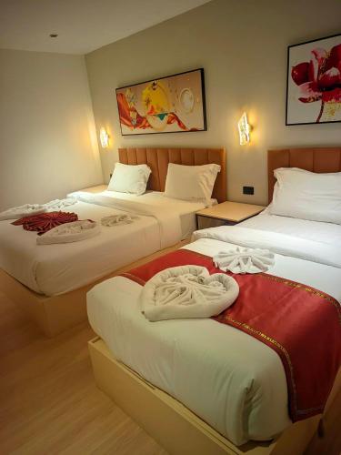 a hotel room with two beds with towels on them at Hotel Soni Mansion Pratunam in Bangkok