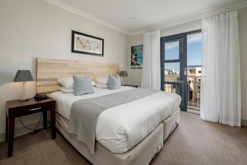 een slaapkamer met een groot bed en een raam bij Harbour House Hotel - Harbour Square in Hermanus