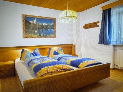 a bedroom with a bed with blue and yellow pillows at THALERHOF Onach Dolomites - Kronplatz in San Lorenzo di Sebato