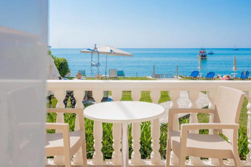 a table and chairs on a balcony overlooking the ocean at Sea View in Laganas
