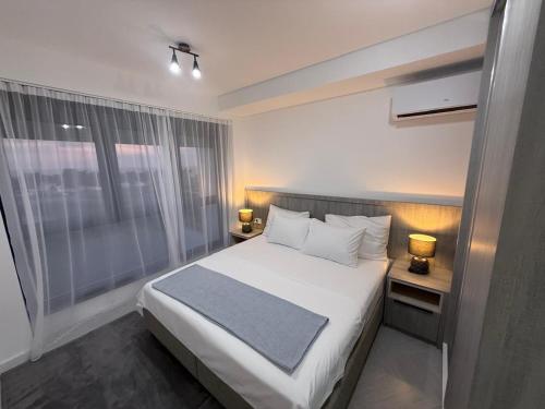 a bedroom with a white bed and a window at B1 first line apartments in Šušanj
