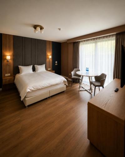 a bedroom with a bed and a table and chairs at Syndicate Lodging Aparthotel in Cluj-Napoca