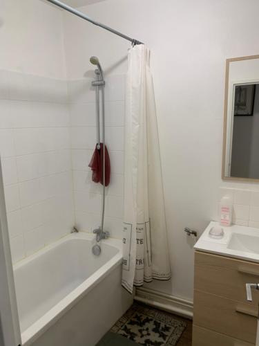 a white bathroom with a tub and a sink at Ma maison in Bonneuil-Matours