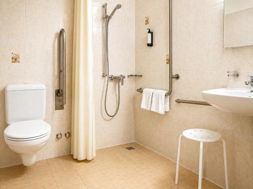 a bathroom with a toilet and a sink and a shower at Parkhotel Emmaus - Casa del Sole in Ascona