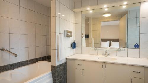 a bathroom with a tub and a sink and a bath tub at Radisson Blu Limfjord Hotel, Aalborg in Aalborg