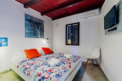 a bedroom with a bed and a tv and a chair at Stone Villa with sea view and pool in Smokvica