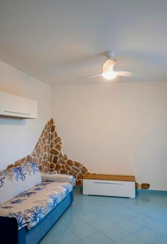 a room with a bed and a ceiling fan at Onda Blu House in Procida