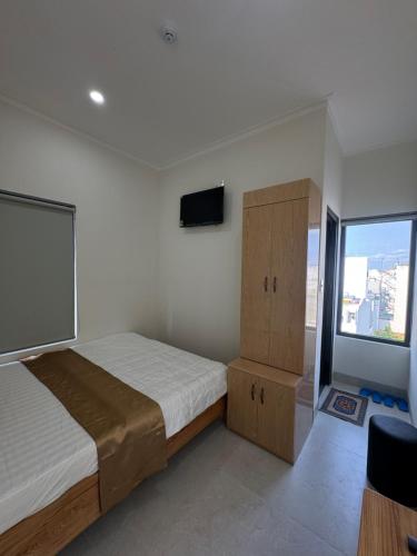 a bedroom with a bed and a large window at Morgan Hotel in Ấp Bình Hưng