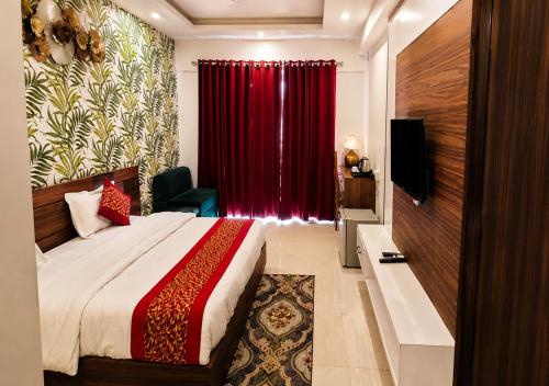 a hotel room with a bed and a red curtain at Joygaon Hotel & Resorts in Jhajjar