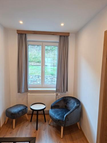 a living room with two chairs and a window at Ferienhaus Gebetsberger in Spitz