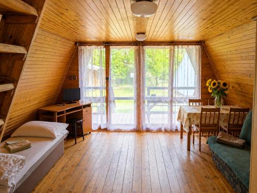 a room with a bed and a desk and a table at Osada Kujanki - domek wakacyjny in Zakrzewo
